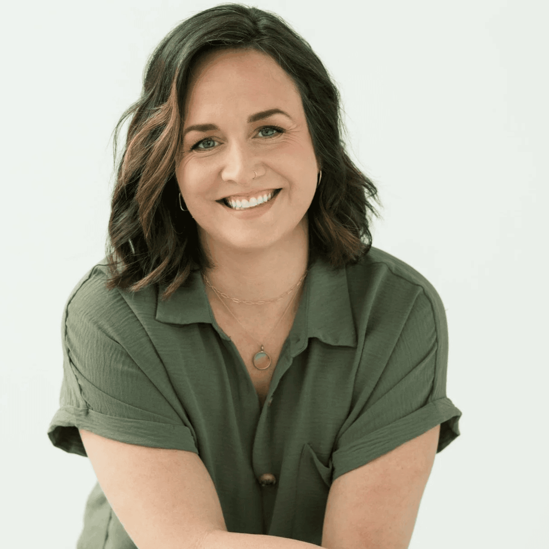 Smiling woman giving a piggyback ride to a laughing young girl.